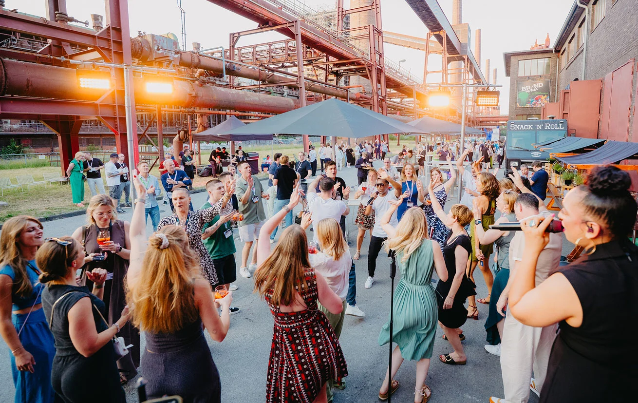 Gäste der BRANDmania 2026 feiern bei Live-Musik auf dem Außengelände der Grand Hall Zollverein in Essen.